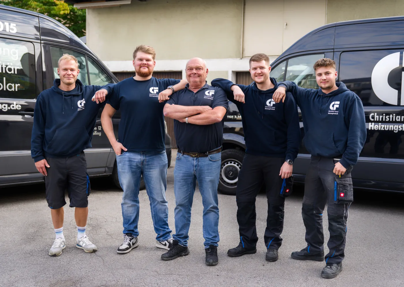 Das Team der Christian Fenzl Heizungstechnik vor den Firmenfahrzeugen in Gräfelfing bei München