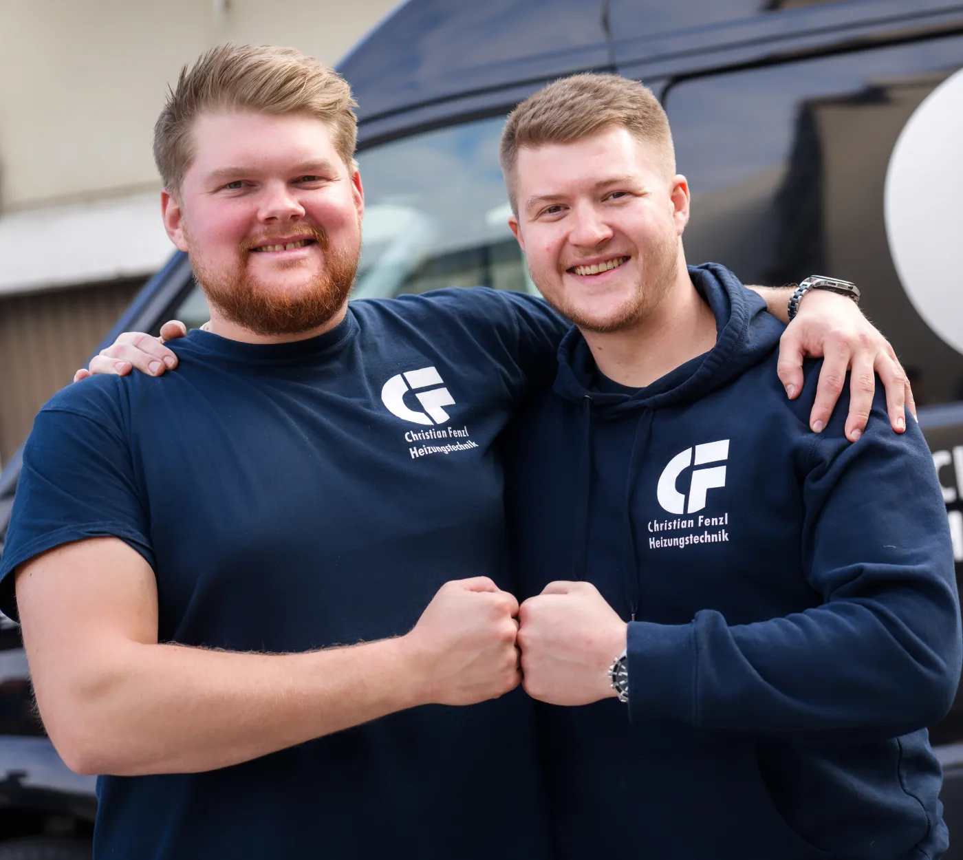 Zwei Mitarbeiter des Kundendienstes der CF Heizung vor dem Firmenfahrzeug